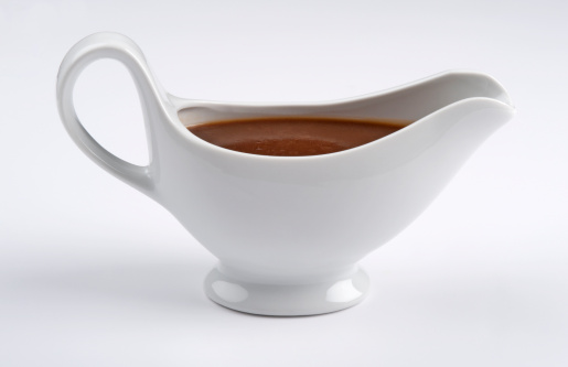 White china gravy boat isolated on white background.Front view.Single object and no people.There are meat sauce in the gravy boat.Close up. Studio shot,Side view and copy Space.Horizontal photography.