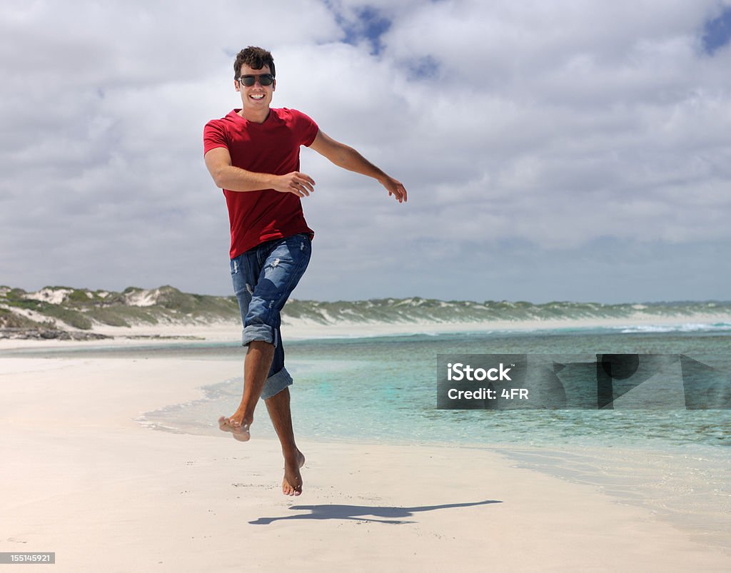 Bell'uomo saltando in una spiaggia appartata (XXXL - Foto stock royalty-free di Saltellare