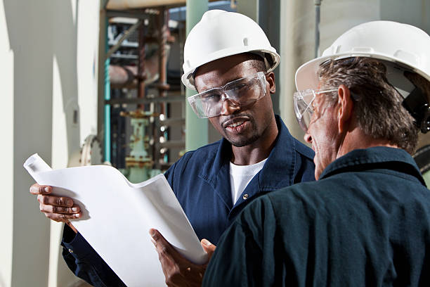 istock Multiracial industrial workers reviewing plans 155146066