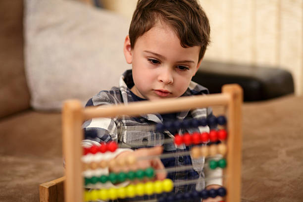 A young boy using an abacus with a blurry background stock photo