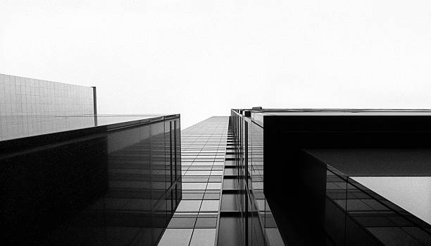 looking up at a glass skyscraper - mimari fotoğraflar stok fotoğraflar ve resimler