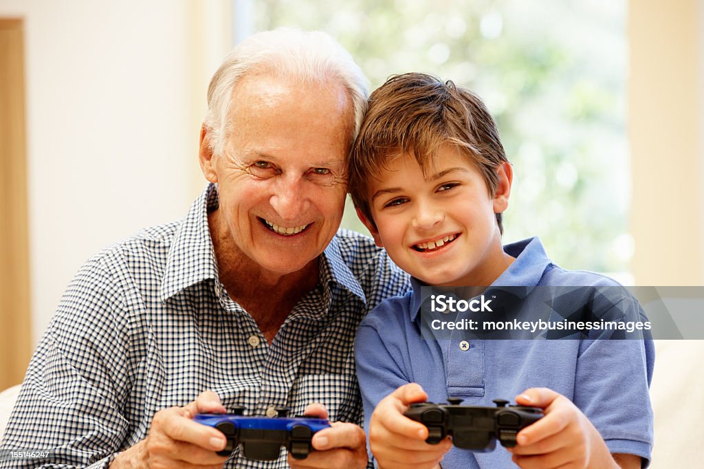 Nonno e nipote giocare a giochi per computer - Foto stock royalty-free di 70-79 anni