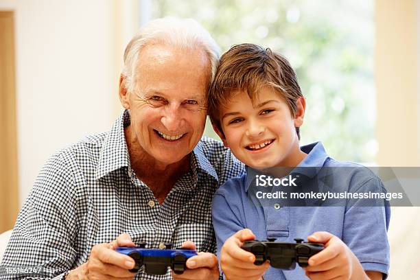 Nonno E Nipote Giocare A Giochi Per Computer - Fotografie stock e altre immagini di 70-79 anni - 70-79 anni, 8-9 anni, Adulto