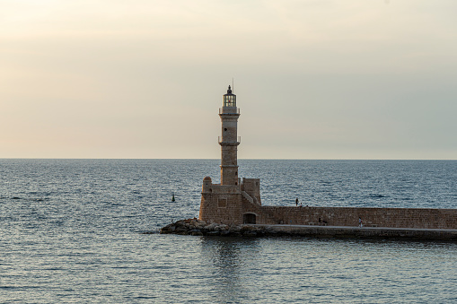 Scenery with beautiful ancient lighthouse surrounded by the sea. Seaport Chania, Crete island, Greece.