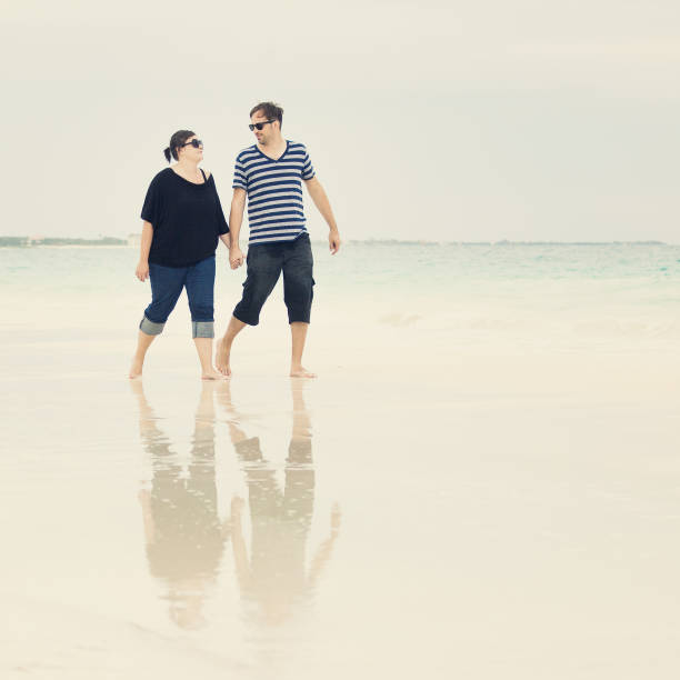 istock young couple walking at the beach 155147144