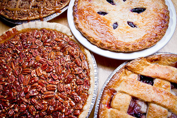 Variety of Pies Lattice Crust Fruit Pie closeup on wooden table including apple caramel, apple berry, pecan and blueberry pies sweet pie stock pictures, royalty-free photos & images
