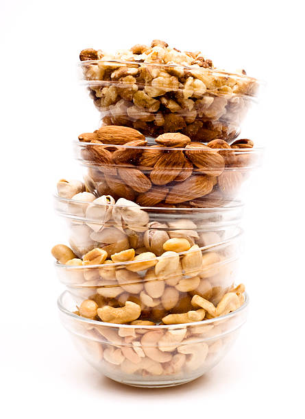Glass bowls with almonds, cashew nuts, pistachios, peanuts stock photo