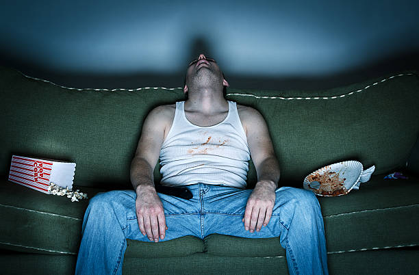 sloppy persona duermen en el sofá en la sala de estar - television boredom men sofa fotografías e imágenes de stock
