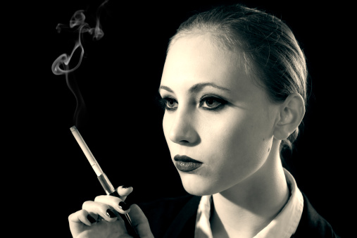 Young woman smoking, with a mystery look.