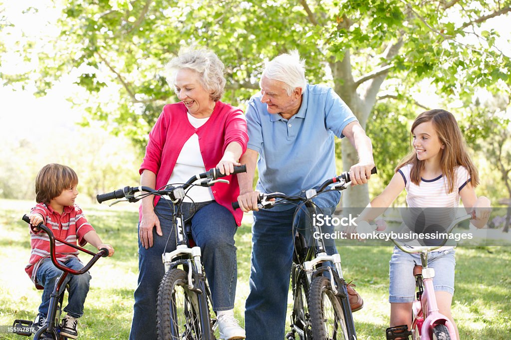Seniors and grandchildren on bikes Seniors and grandchildren on bikes looking at young boy Child Stock Photo