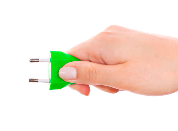 istock Woman hand holding green plug isolated on white 155147940
