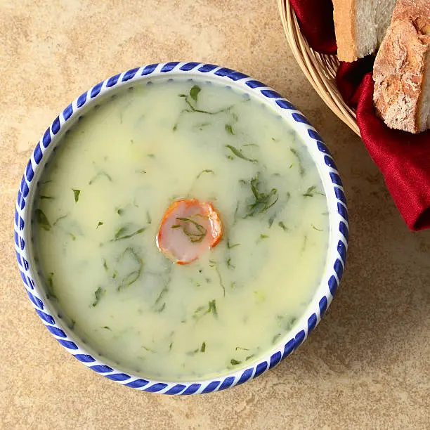 A traditional and popular Portuguese soup made of potatoes, kale, and onions garnished with a slice of chourico.
