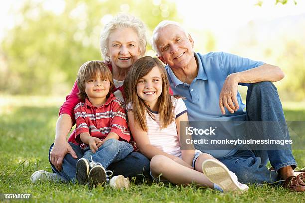 Senior Couple And Grandchildren In Park Stock Photo - Download Image Now - 4-5 Years, 70-79 Years, 8-9 Years
