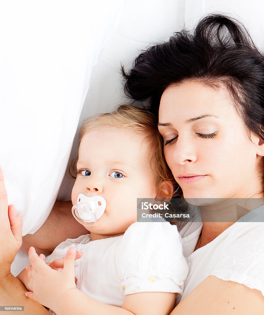Giovane famiglia a letto - Foto stock royalty-free di Ciuccio
