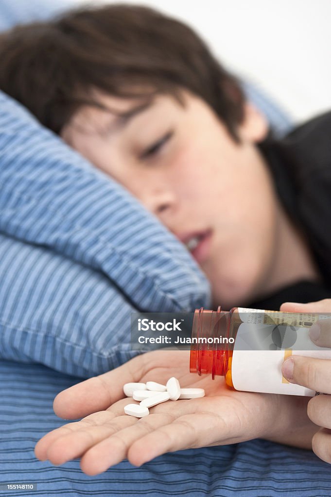 Teenager taking prescription drugs Child lying in bed after taking prescription drugs Pill Stock Photo