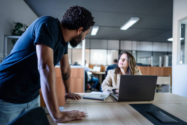 istock Coworkers talking at the office 1551482385