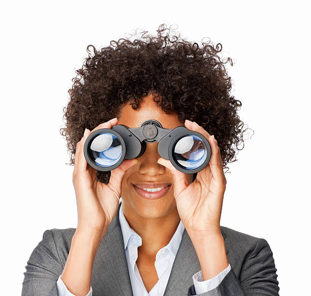 Businesswoman With Binoculars Businesswoman looks at the camera through binoculars. Square shot. Isolated on white. binoculars photos stock pictures, royalty-free photos & images