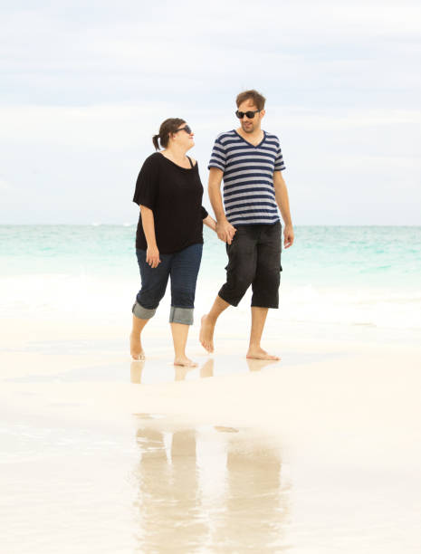 istock young couple walking at the beach 155148309