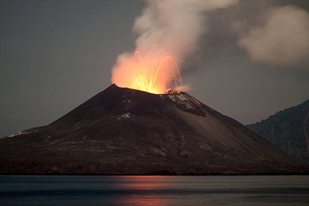 A volcano Mount Semeru emitting smoke against a pastel sky during sunrise