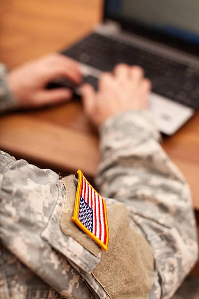 american soldier escribiendo en una computadora port�átil - government flag american culture technology fotografías e imágenes de stock