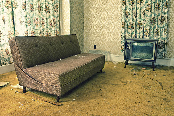 Poor Signal A neglected living room in period decor. Television with static. dirty old couch stock pictures, royalty-free photos & images