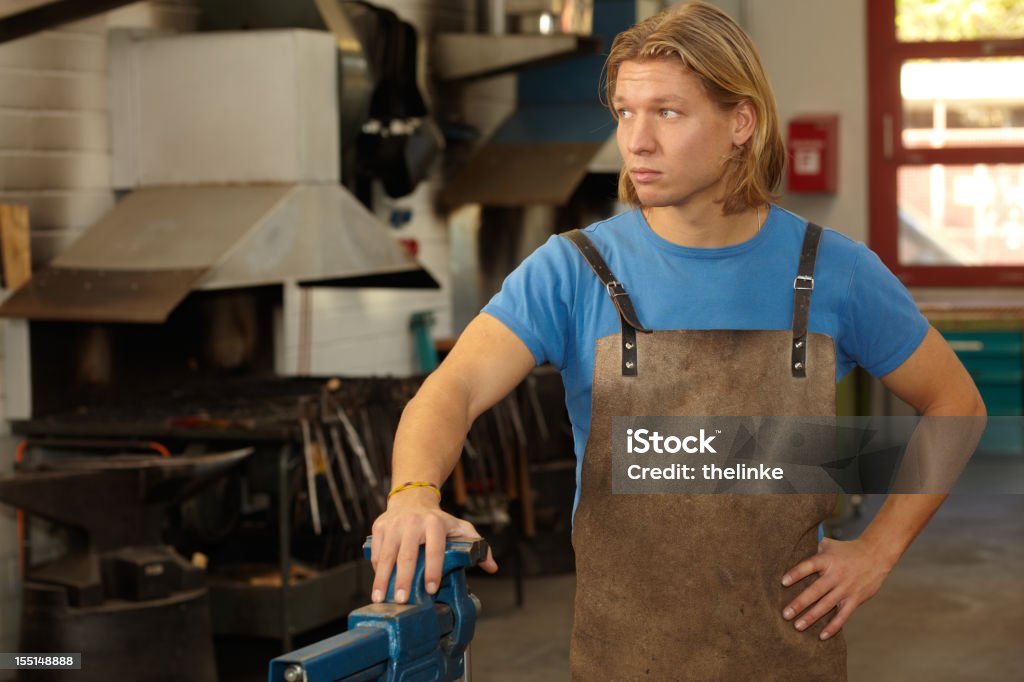 Portrait of a young blacksmith Portrait of a young blacksmith in his factory. Blond Hair Stock Photo