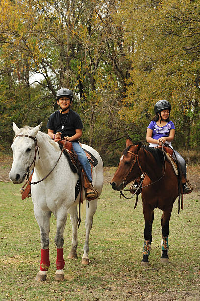 duas crianças de equitação no texas - white purebred horse riding sports traditional sport - fotografias e filmes do acervo