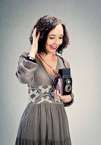 istock Cheerful young woman holding an old camera. 155149179