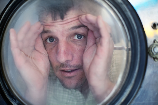 Crazy man looking through the washing machine door