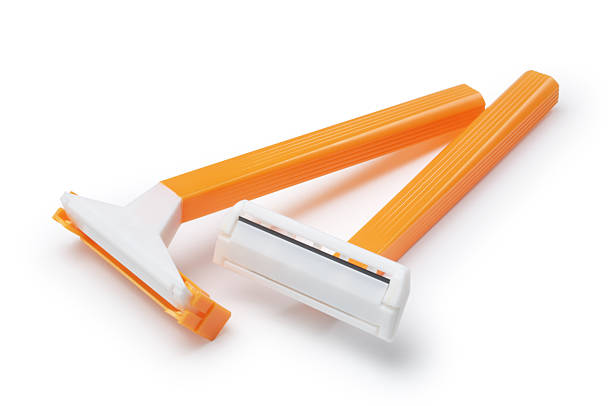 Yellow basic pair of razors in white background Two plastic, disposable razors isolated on white. razor blade stock pictures, royalty-free photos & images