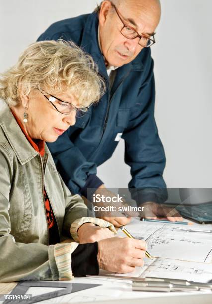 Mulher E Homem Na Mesa De Trabalho - Fotografias de stock e mais imagens de 55-59 anos - 55-59 anos, Adulto, Adulto maduro