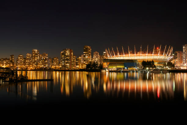 Urban Silhouette of Downtown Vancouver, Canada Harbor city night scene with skyscrapers and buildings in Vancouver, BC, Canada with BC Place Stadium in the foreground vancouver at night stock pictures, royalty-free photos & images