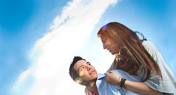 istock Young couple locking eyes outside under blue sky 155149710