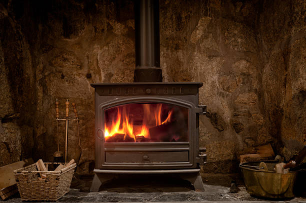 Cozy Fireplace With A Wood Burning Stove A Fireplace With A Wood Burning Stove wood burning stove stock pictures, royalty-free photos & images