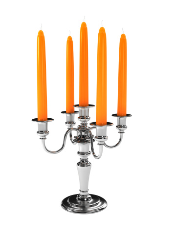 A vertical shot of a silver candleholder with white candles.