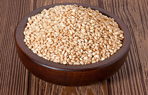 Bio natural sesame seeds on wooden bowl.