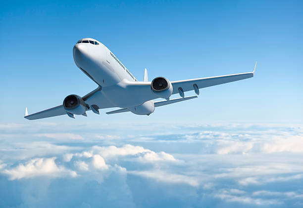 Passenger jet airplane flying above clouds stock photo