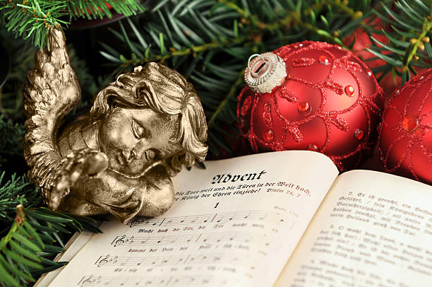 angel sleeping on christian hymnal book with christmas ornaments - kerstengel stockfoto's en -beelden