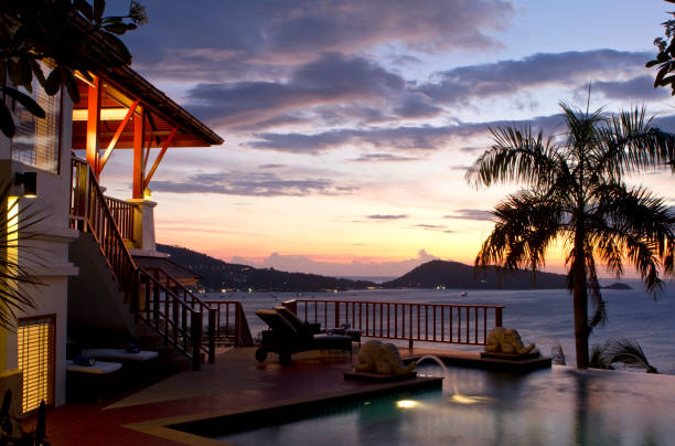 View of a luxury pool villa facing the sunset in Phuket, Thailand.