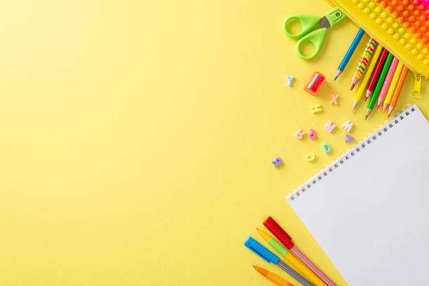 istock Experience the joy of studying art at school with this creative top view composition: an album and a variety of vivid stationery displayed on a yellow isolated background, perfect for text or adverts 1551510342