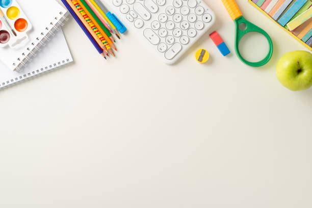 istock Embrace the convenience of distant learning with this top-down photo featuring a keyboard, notebooks and office supplies on white background. Ample copy-space available for text or ads 1551510545