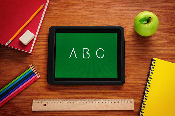 aprendiendo a leer con tablet pc - textbook book apple school supplies fotografías e imágenes de stock