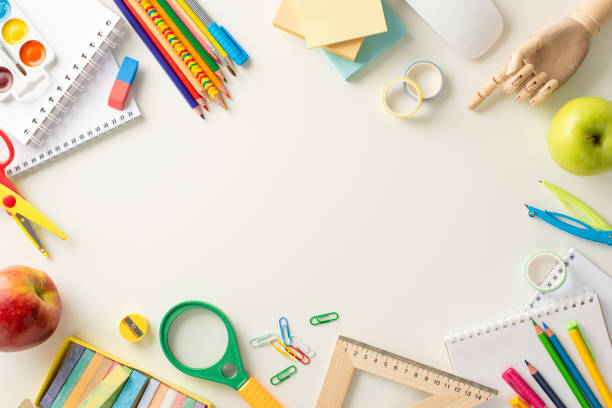 Embark on a successful educational journey with this creative top-down photograph of meticulously arranged school supplies on white background. Use empty space to include text or advertisements