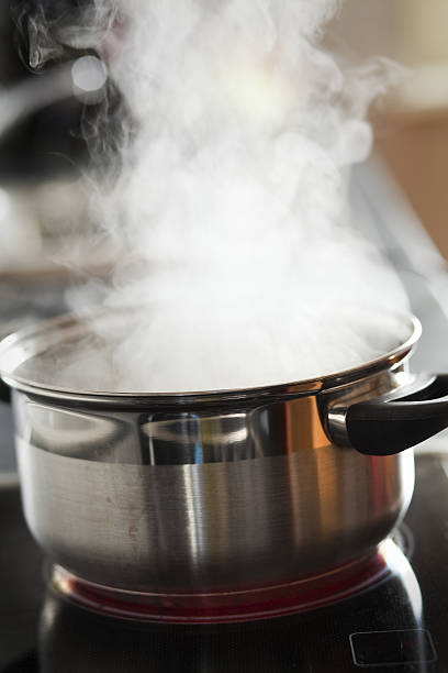 cooking water close up of a open cooking steel pot on ceran field boiled photos stock pictures, royalty-free photos & images