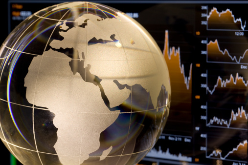 Glass globe showing European continents over financial data charts.