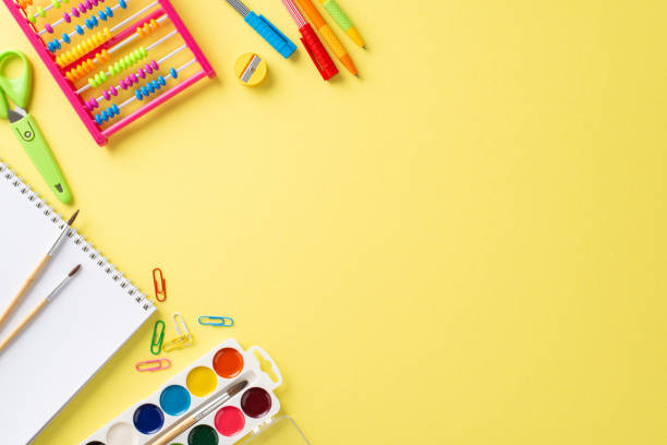 istock Delightful educational essentials captured from above: an array of vibrant school supplies showcased on an isolated yellow background, providing copyspace for text or promotional messages 1551517227