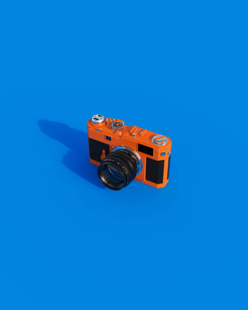 istock Orange vintage camera 80s 90s nostalgia retro silver chrome black blue background 1551517770