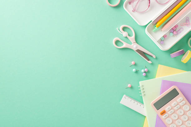 istock Transform your learning space with this stunning setup. Top view highlights girlish diaries, pencil case, pens, adhesive tape, scissors, ruler on teal backdrop, providing empty area for text or advert 1551518273