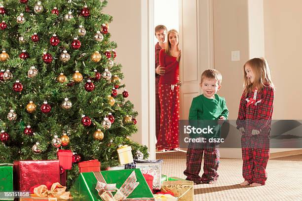 Photo libre de droit de Noël Matin Heureux Les Enfants Tandis Que Les Parents Regarder banque d'images et plus d'images libres de droit de 2-3 ans