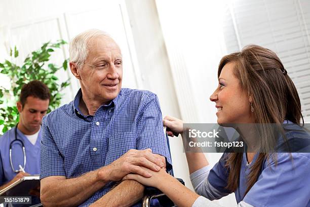 Physical Therapist Or Nurse Consoling Senior Man Patient Wheelchair Doctor Stock Photo - Download Image Now